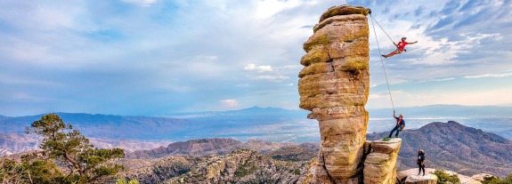 Tucson mountain range background view with students rock climbing
